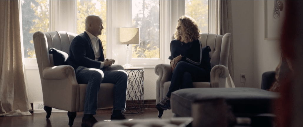 Wrongful death lawyer Kyle Bachus speaks with a client as they sit in a living room