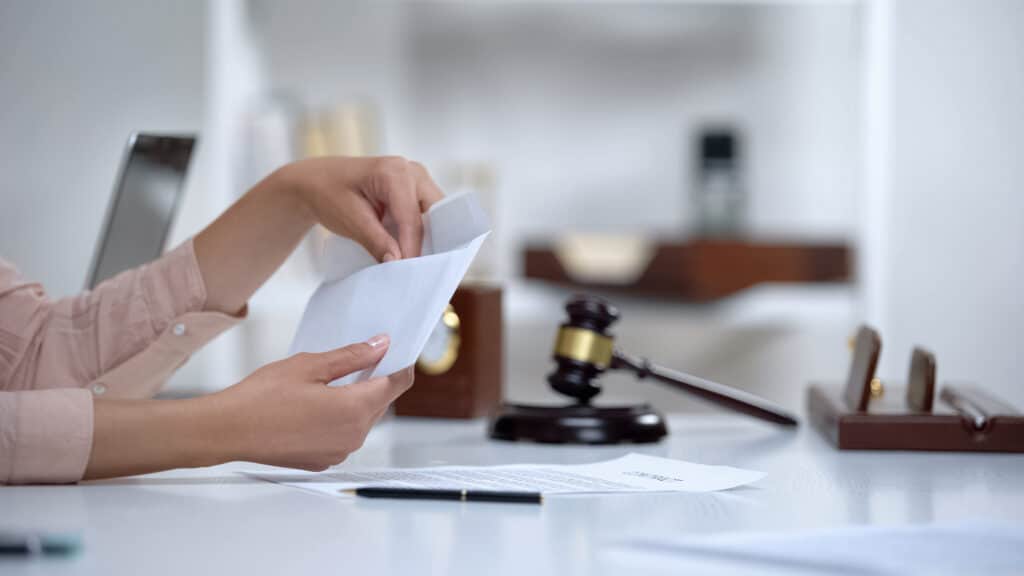 person holding an envelope with wrongful death claim documents inside