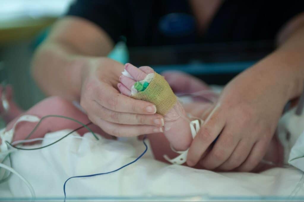 mother holding premature baby's foot