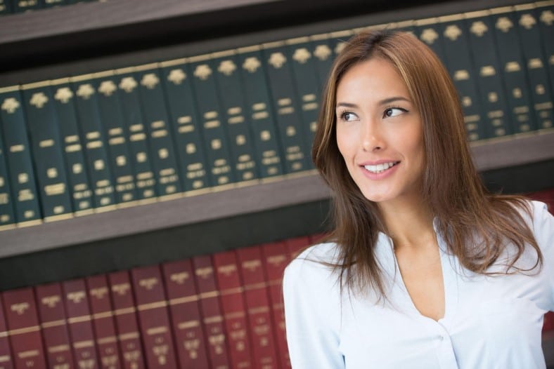 lady wrongful death lawyer standing in front of book shelf 