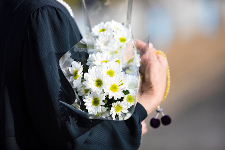 person holding flowers at a funeral after a wrongful death