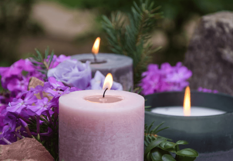purple flowers surround lit candles for a wrongful death memorial