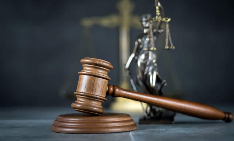 A gavel in front of a Lady Justice statue on a burn injury lawyer's desk. 