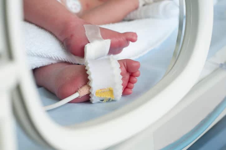 Focus is on a newborn's feet in the NICU.