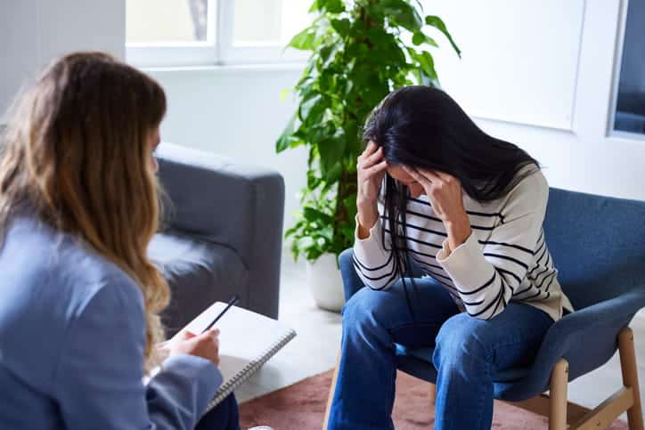 A woman in distress speaking to a therapist.