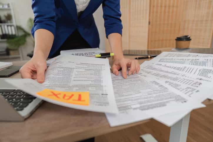 A wrongful death lawyer goes through tax forms in regard to a client's case. 